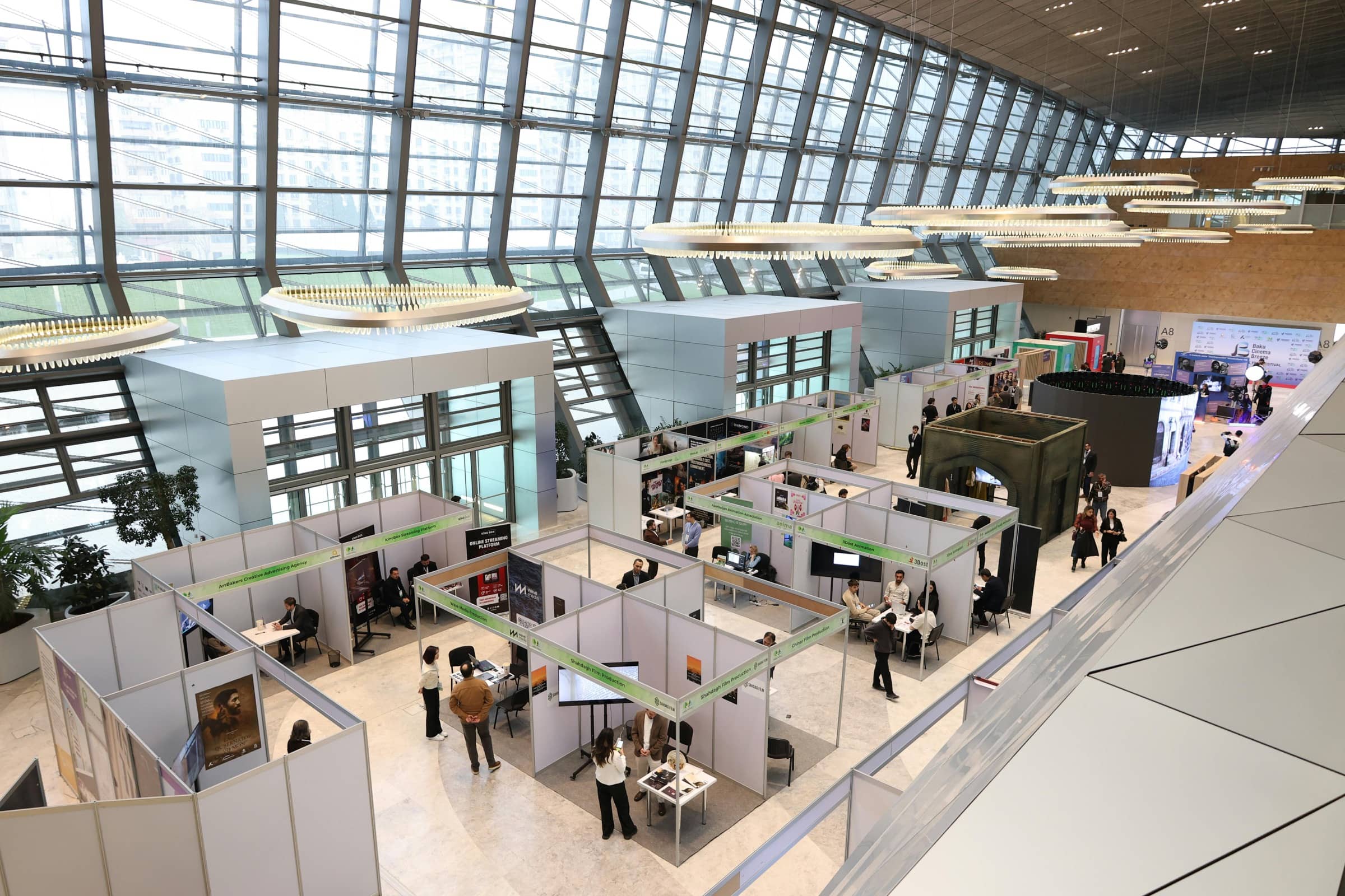 Wide view of a modern trade show floor with exhibition booths and attendees