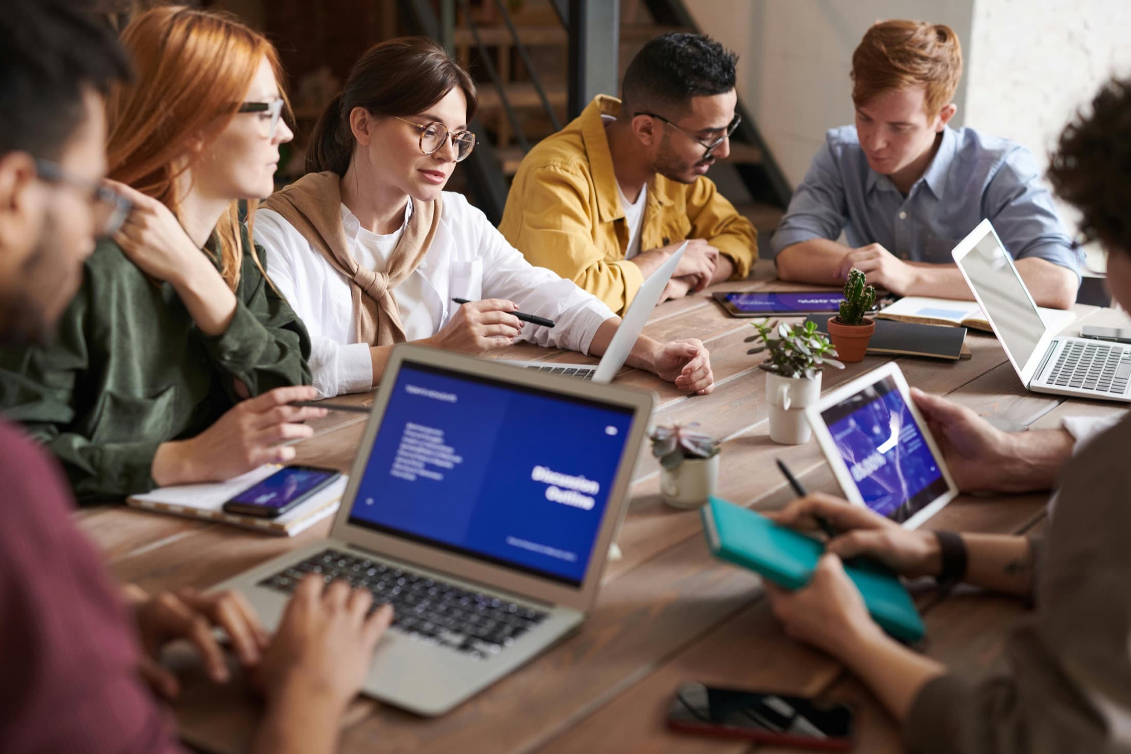 Convention housing specialists reviewing online requests across laptops and shared screens